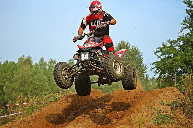 ATV Quad On Dirt Track Mud Ramp Jumping In Air Tires